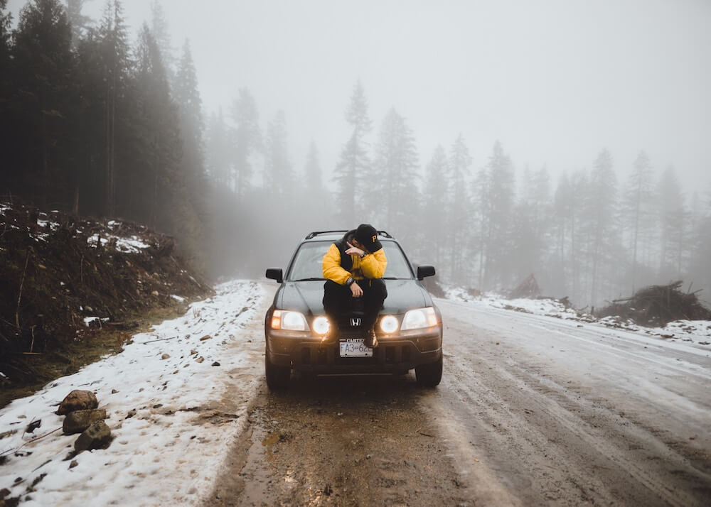 image of man sat on car