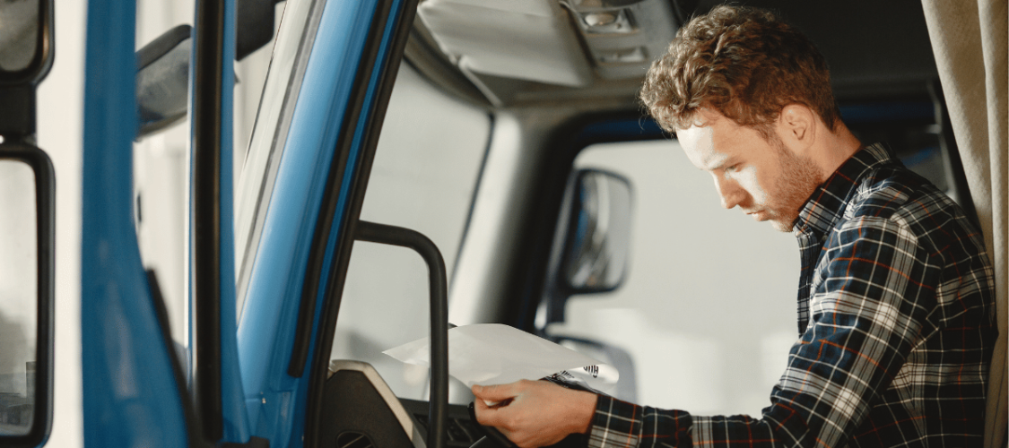 an hgv driver sits in the vehicle filling out a form