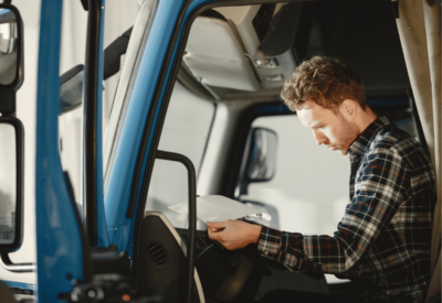 an hgv driver sits in the vehicle filling out a form
